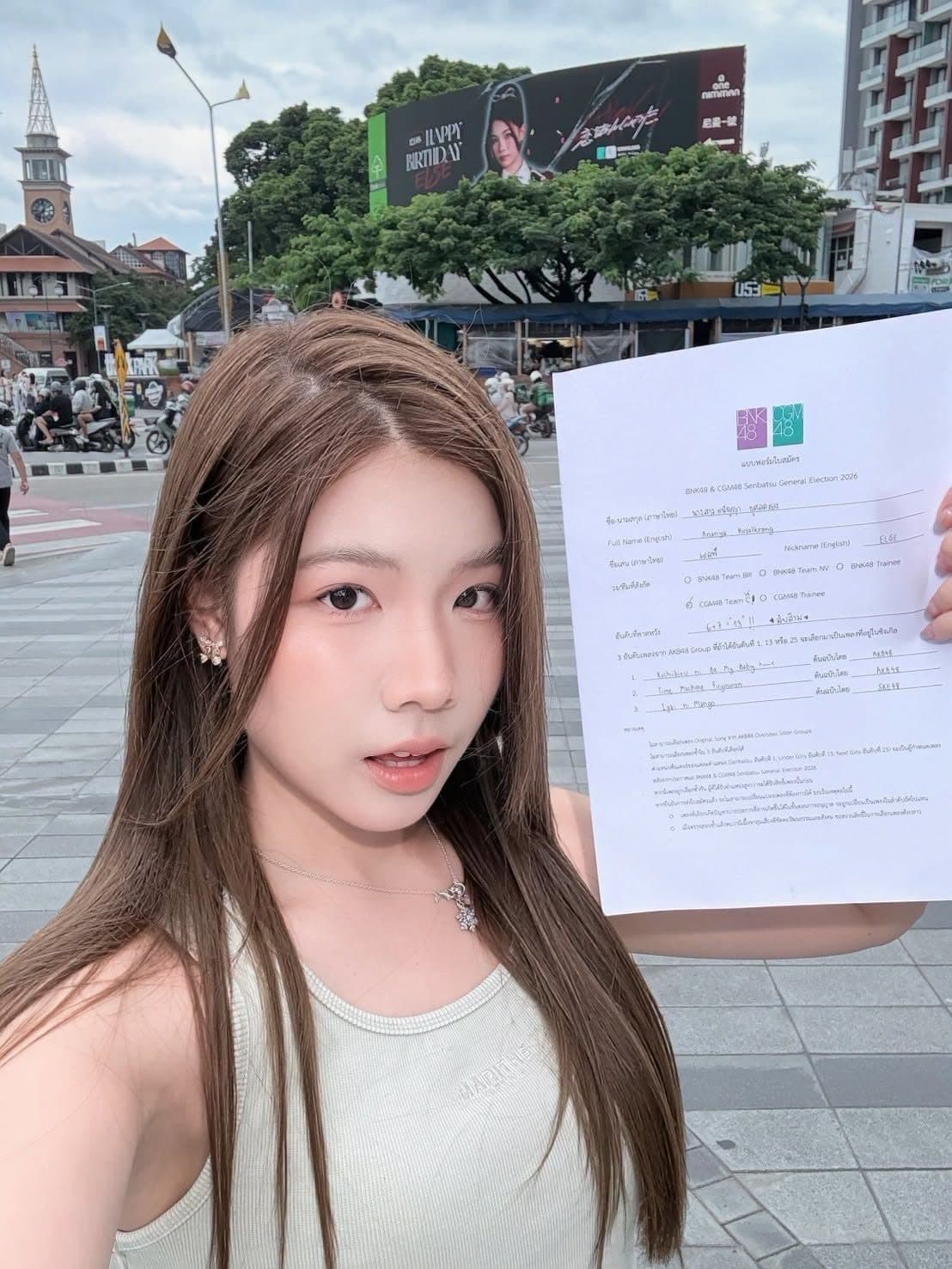 เอลฟ์ถือใบสมัคร General Election พร้อมพื้นหลังเป็นบิลบอร์ดวันเกิดของตัวเอง